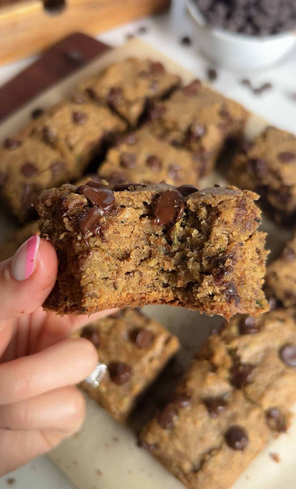 Close-up of a zucchini chocolate chip blondie with a bite taken out.