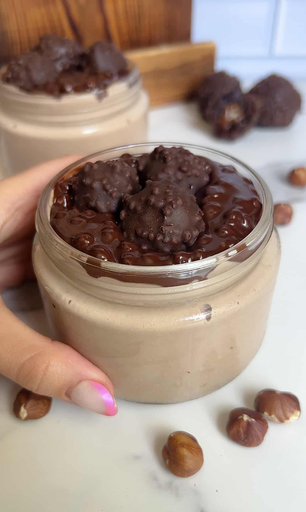 Close‑up of creamy chocolate cottage cheese mousse in a jar with crunchy Ferrero Rocher‑style toppings and glossy ganache, perfect for high‑protein dessert lovers.