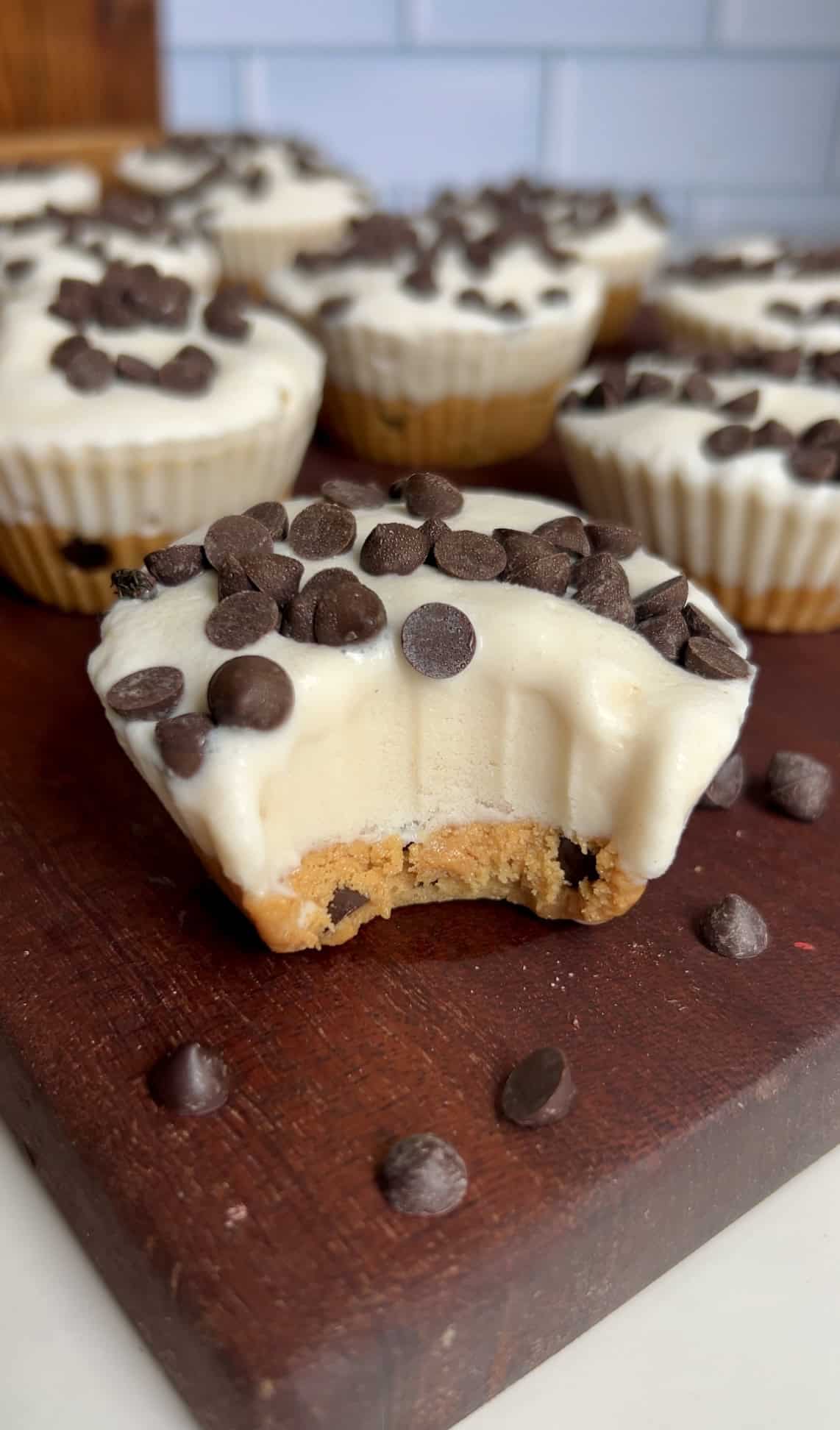 Cookie dough ice cream cup with a bite taken out, revealing the soft cookie dough base and creamy vanilla ice cream layer
