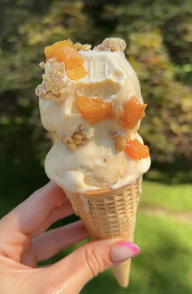 High‑protein peach cobbler ice cream cone with caramelized peaches and crumble topping