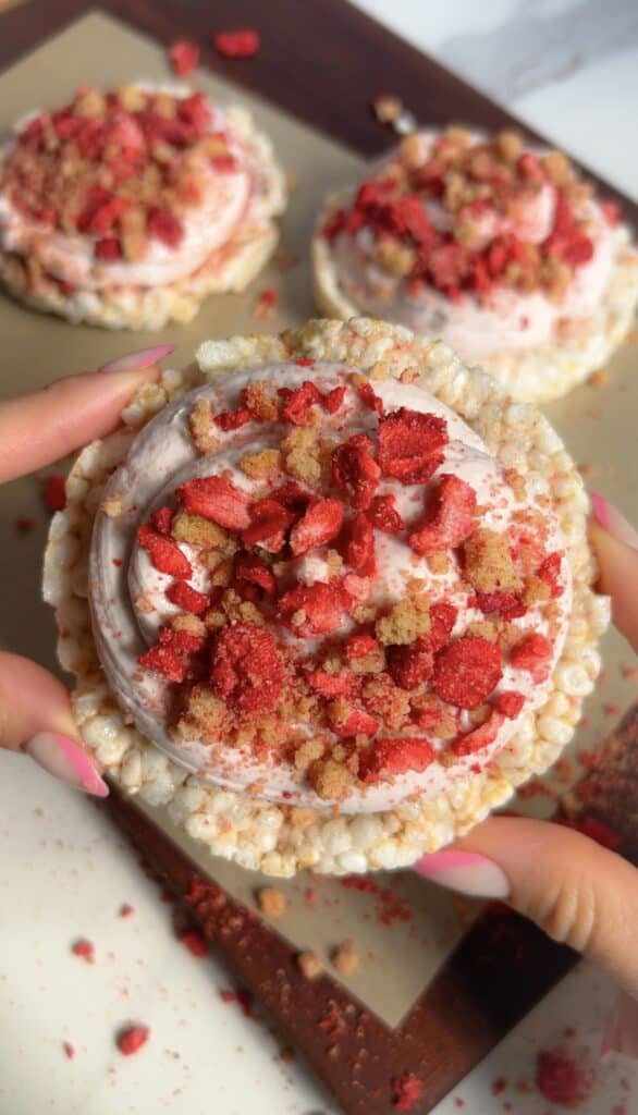 High‑protein strawberry shortcake rice cake topped with Greek yogurt frosting and crumble