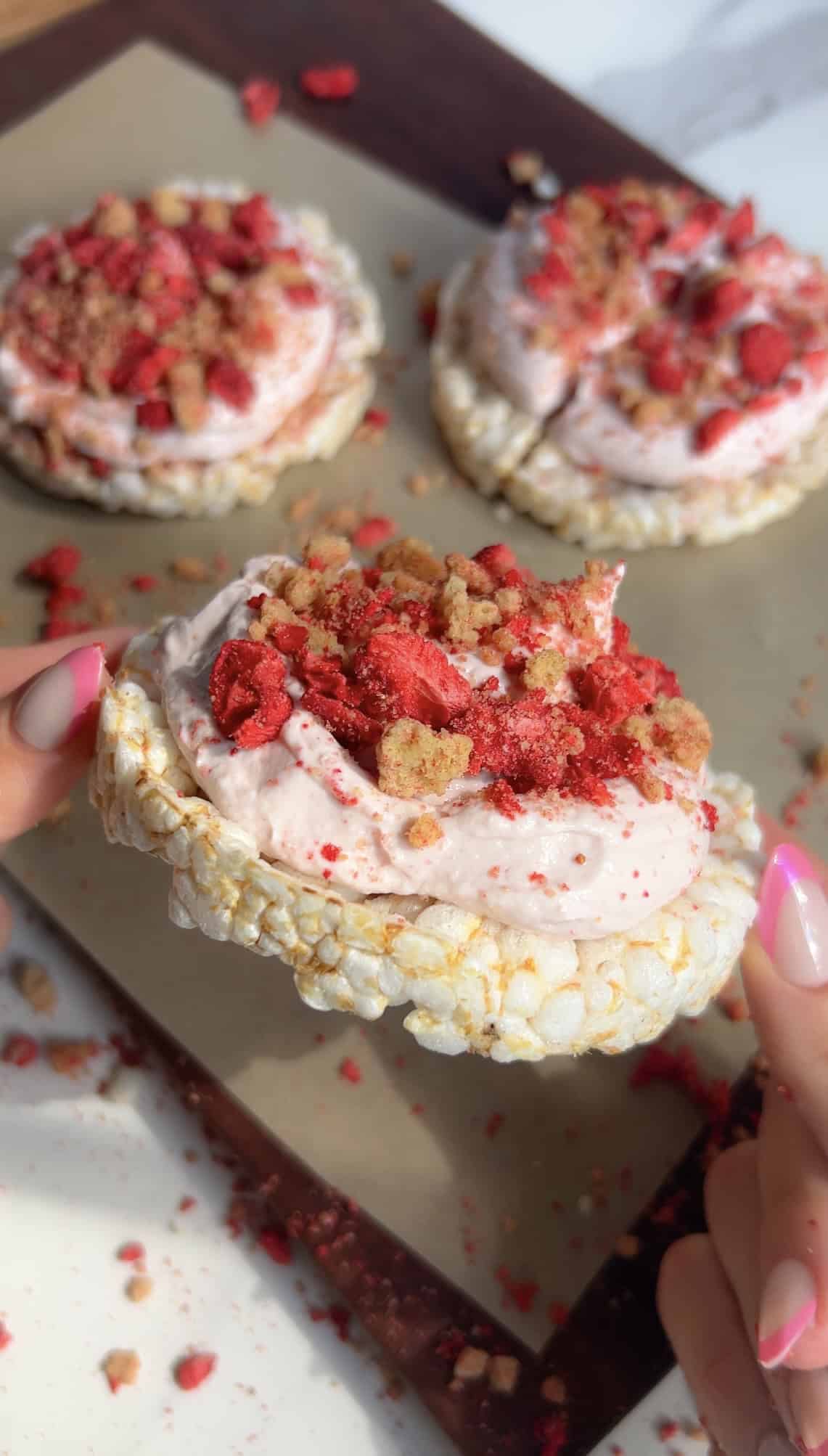 High‑protein strawberry shortcake rice cake topped with Greek yogurt frosting and crumble