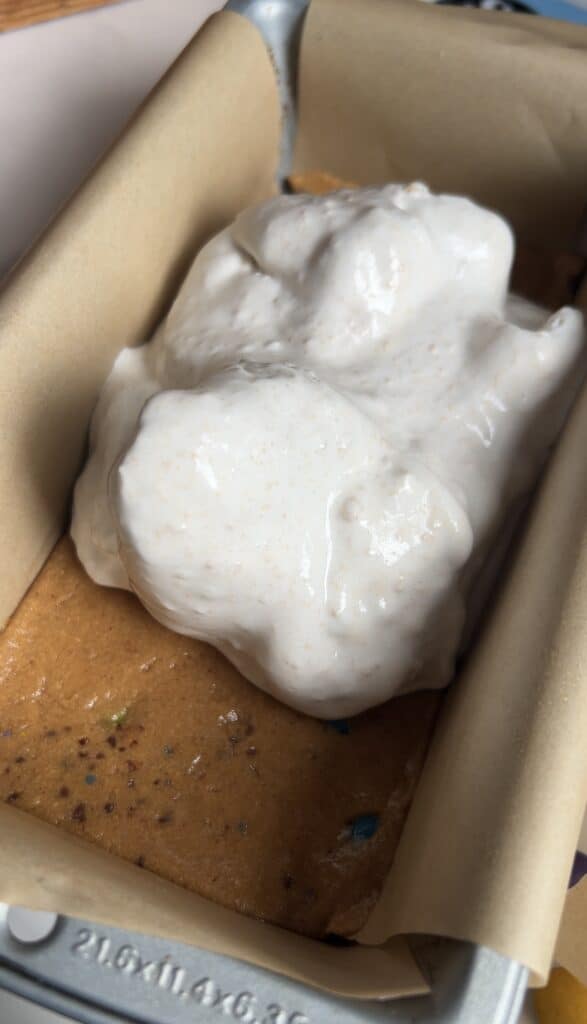 Spreading Cool Whip filling overtop cookie dough base