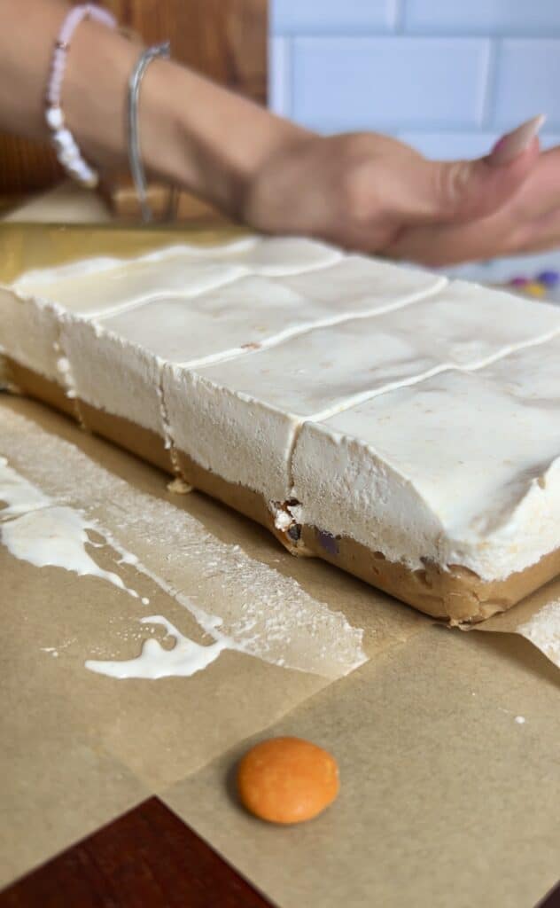 using a large knife to cut through frozen ice cream sandwiches