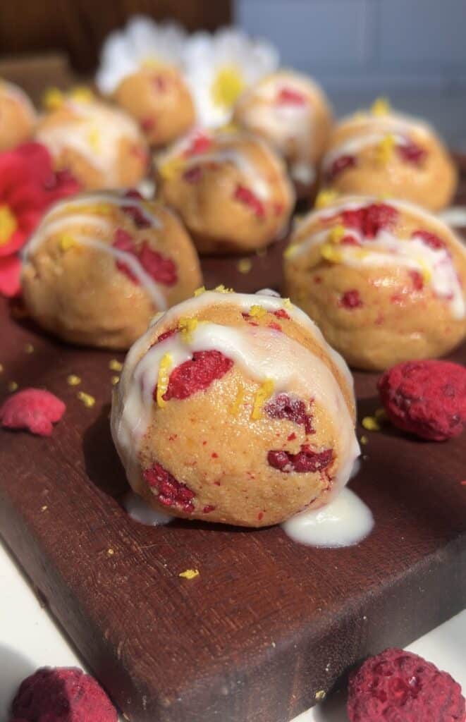Delicious no-bake lemon raspberry protein truffles with white chocolate drizzle.