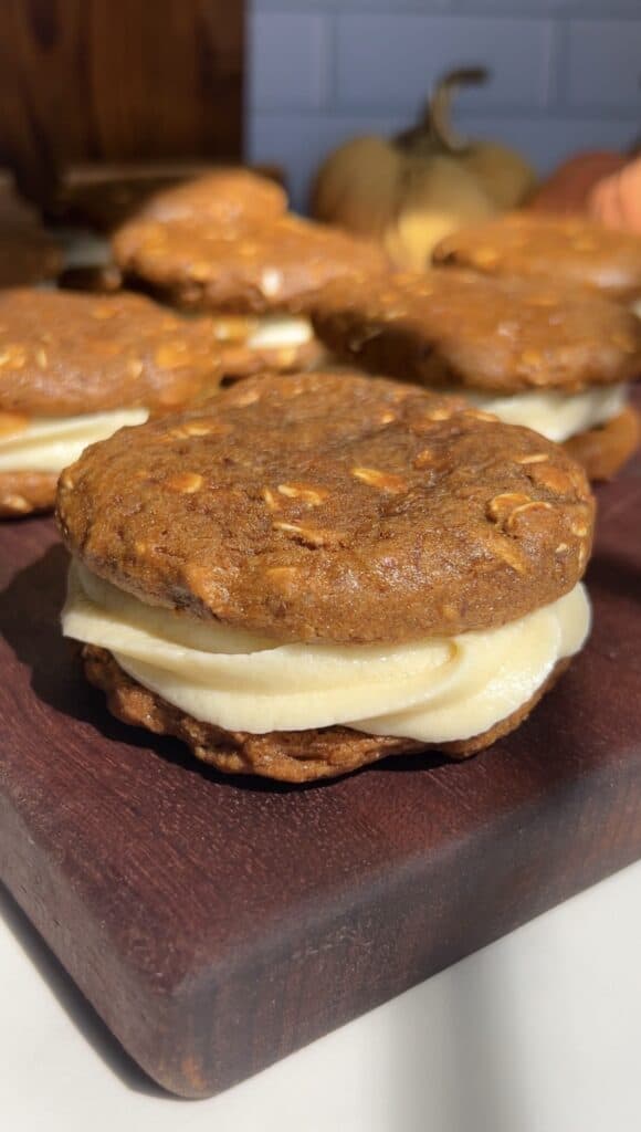 High-protein gluten-free pumpkin oatmeal cream pies on a wooden board.