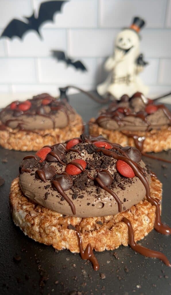 Chocolate rice cakes topped with chocolate and red sprinkles for a healthy Halloween snack.