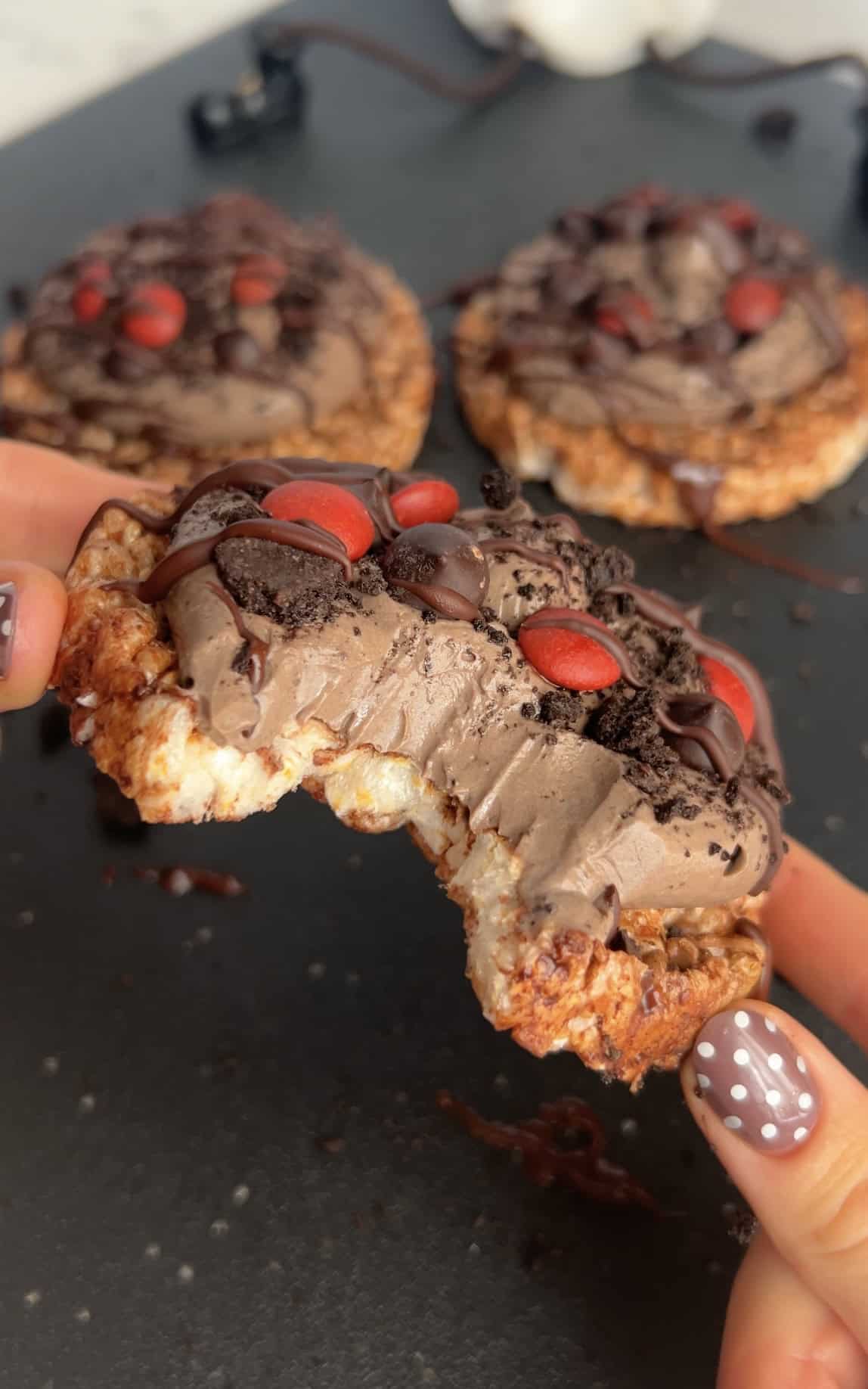Chocolate rice cakes topped with a chocolate greek yogurt mixture, dark chocolate chips, and dye free red candies for a healthy high protein halloween snack.
