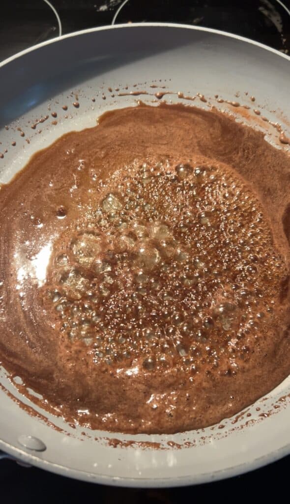 brown sugar caramelizing in a pan for candied pecans