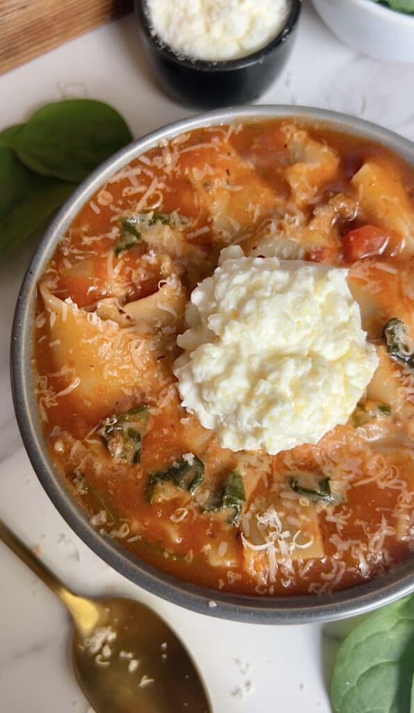Delicious gluten-free lasagna soup with cheese and fresh herbs in a bowl.